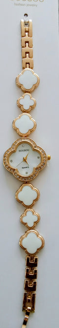 A gold-tone women's watch with a round bezel and a link bracelet featuring alternating white clover-shaped links and a white clover dial.